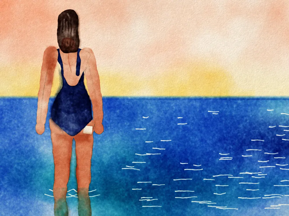 A woman seen from behind standing in the sea, a small HRT patch on her hip.
