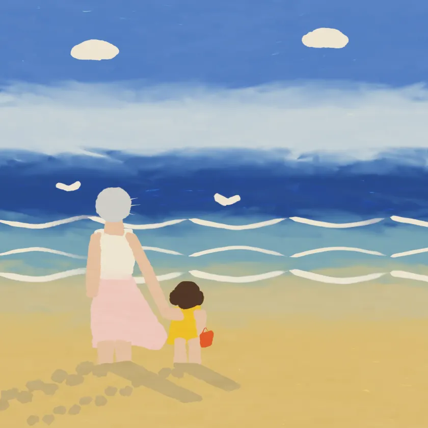 A grandmother holding a small child's hand at the edge of the sea.