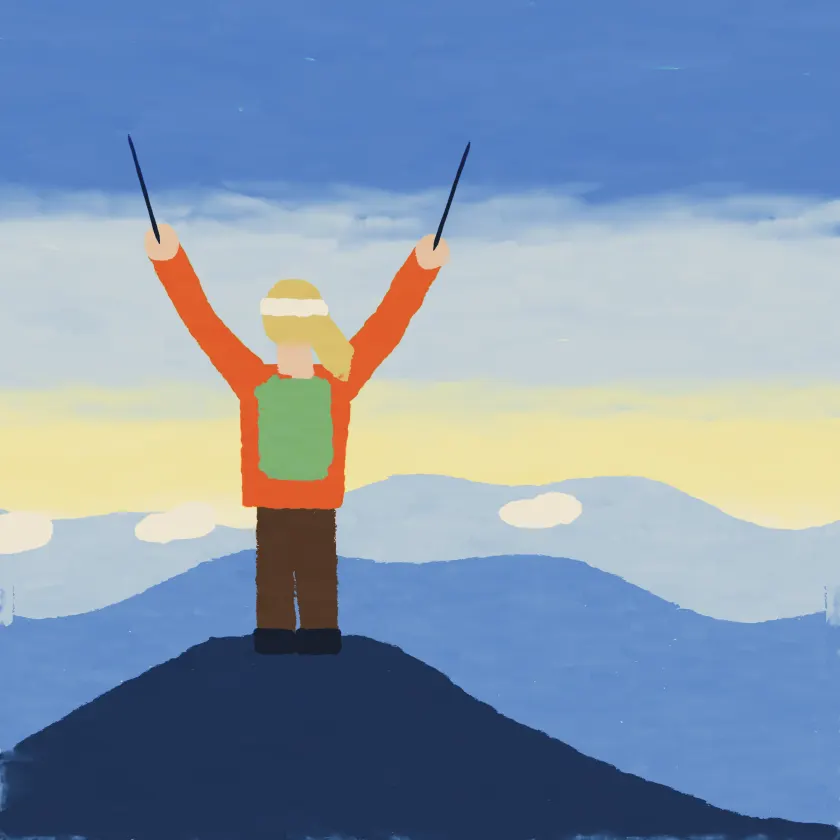 A woman on a mountain top with her walking poles raised in the air.
